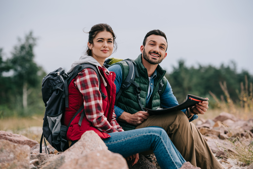 a couple sitting on a rock during hiking trip